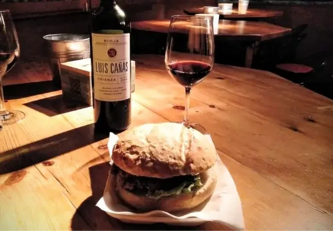 Hamburguesa en el bar Dos Caballos de Sangüesa (Navarra) junto a botella de vino tinto Luis Cañas crianza